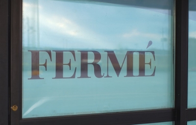 photo représentant une porte fermée avec un panneau indiquant la mention fermé