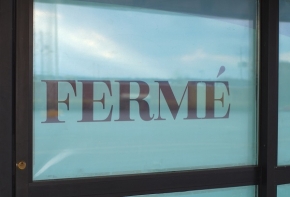 photo représentant une porte fermée avec un panneau indiquant la mention fermé